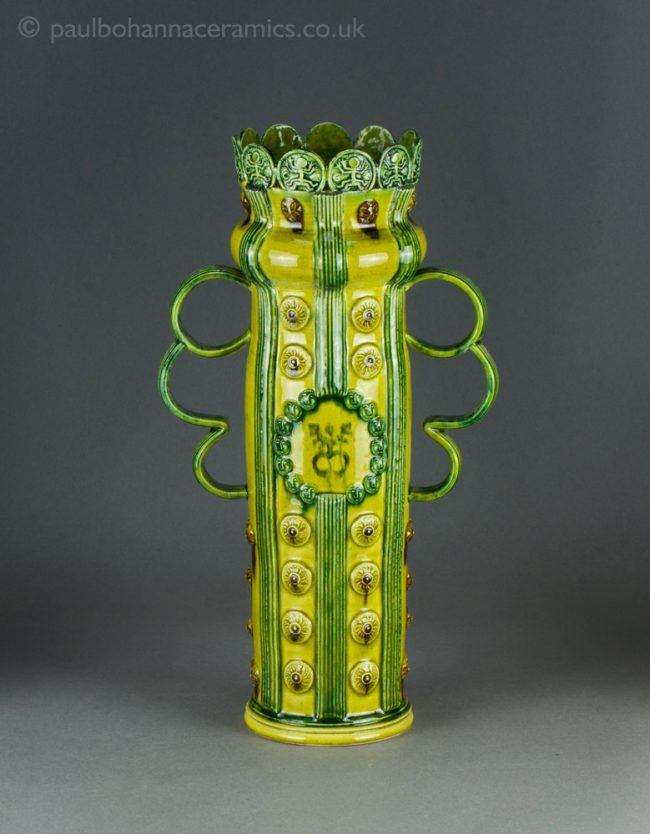 Tall 'Celebration vase' type loving cup with sprigs and birdman print. Front.